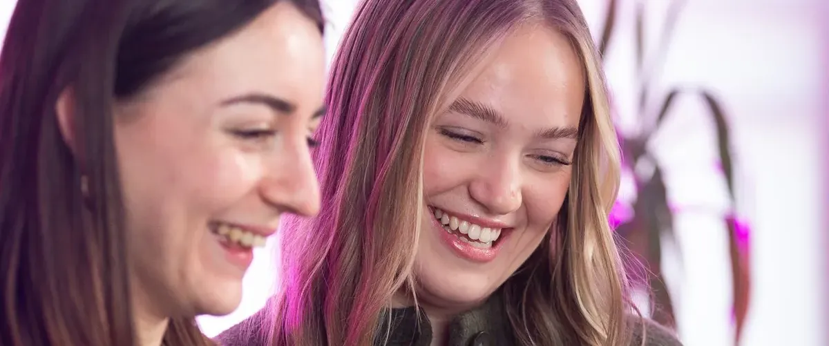 Two marketers laughing over a laptop